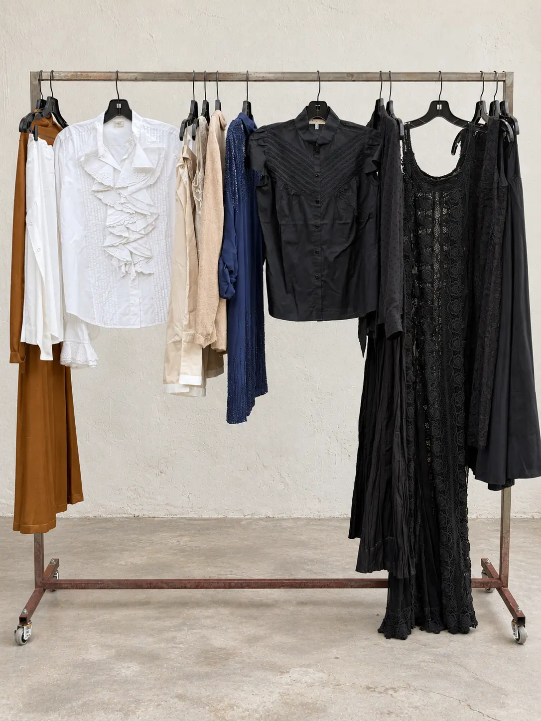 Ruffled blouses and lace dresses on a garment rack